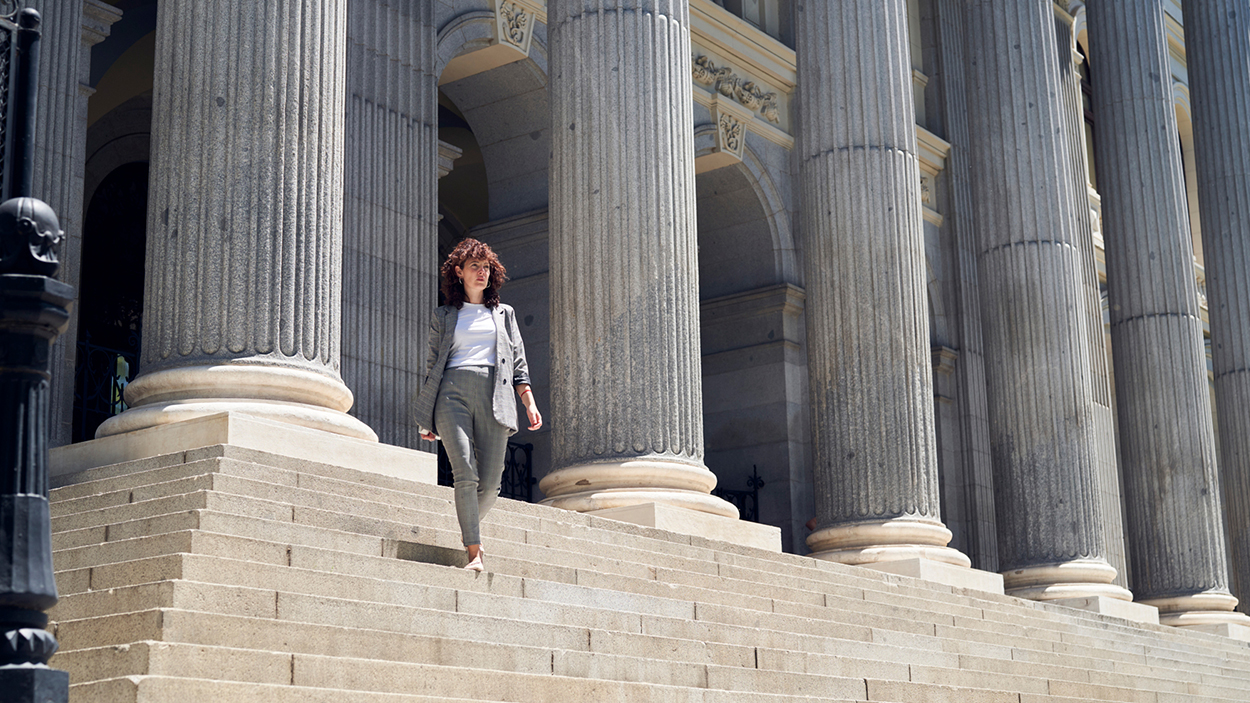 Mujer bajando la escalinata del Palacio de la Bolsa de Madrid