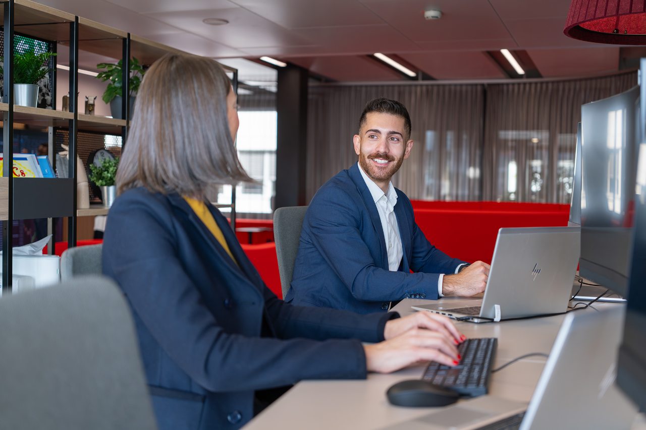 Office environment, two colleagues, man and woman, working