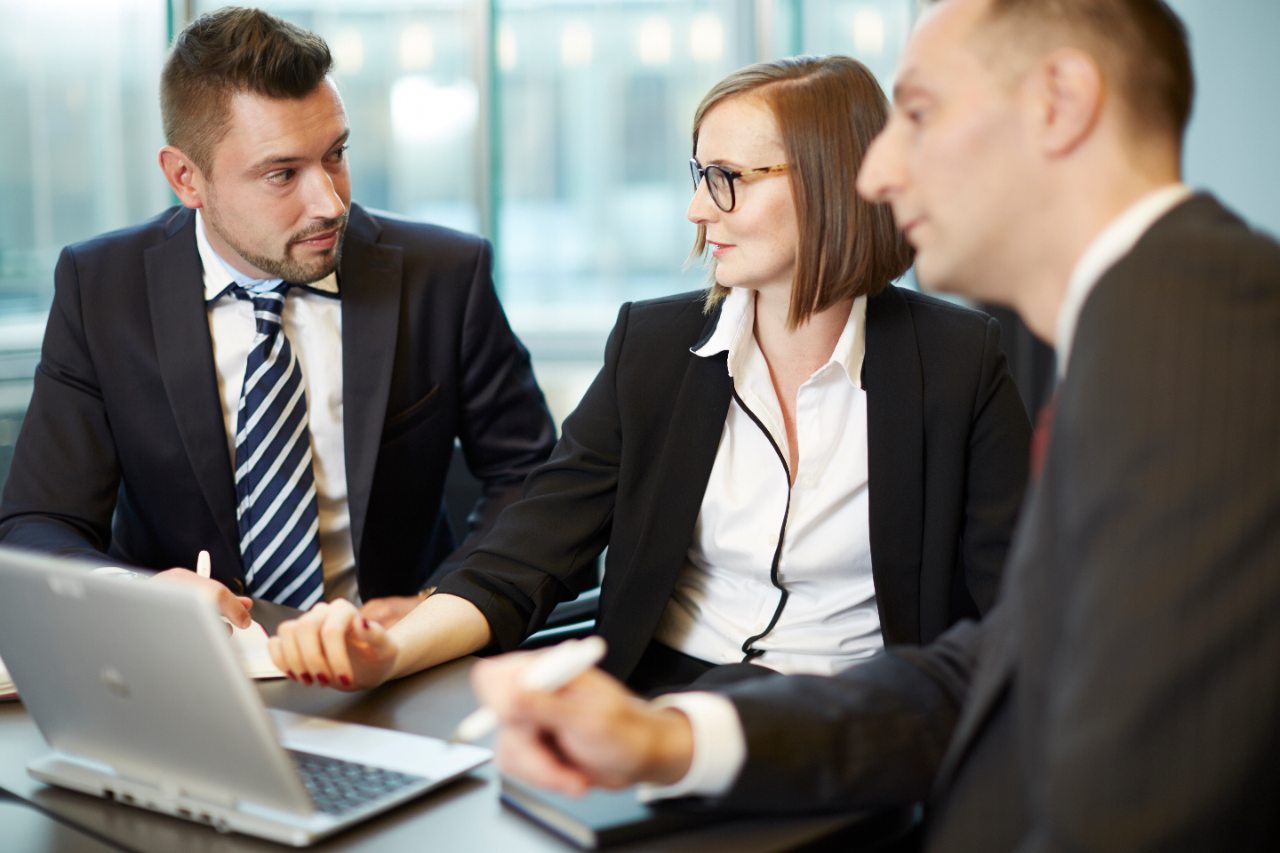 Tres personas discutiendo en frente de una laptop