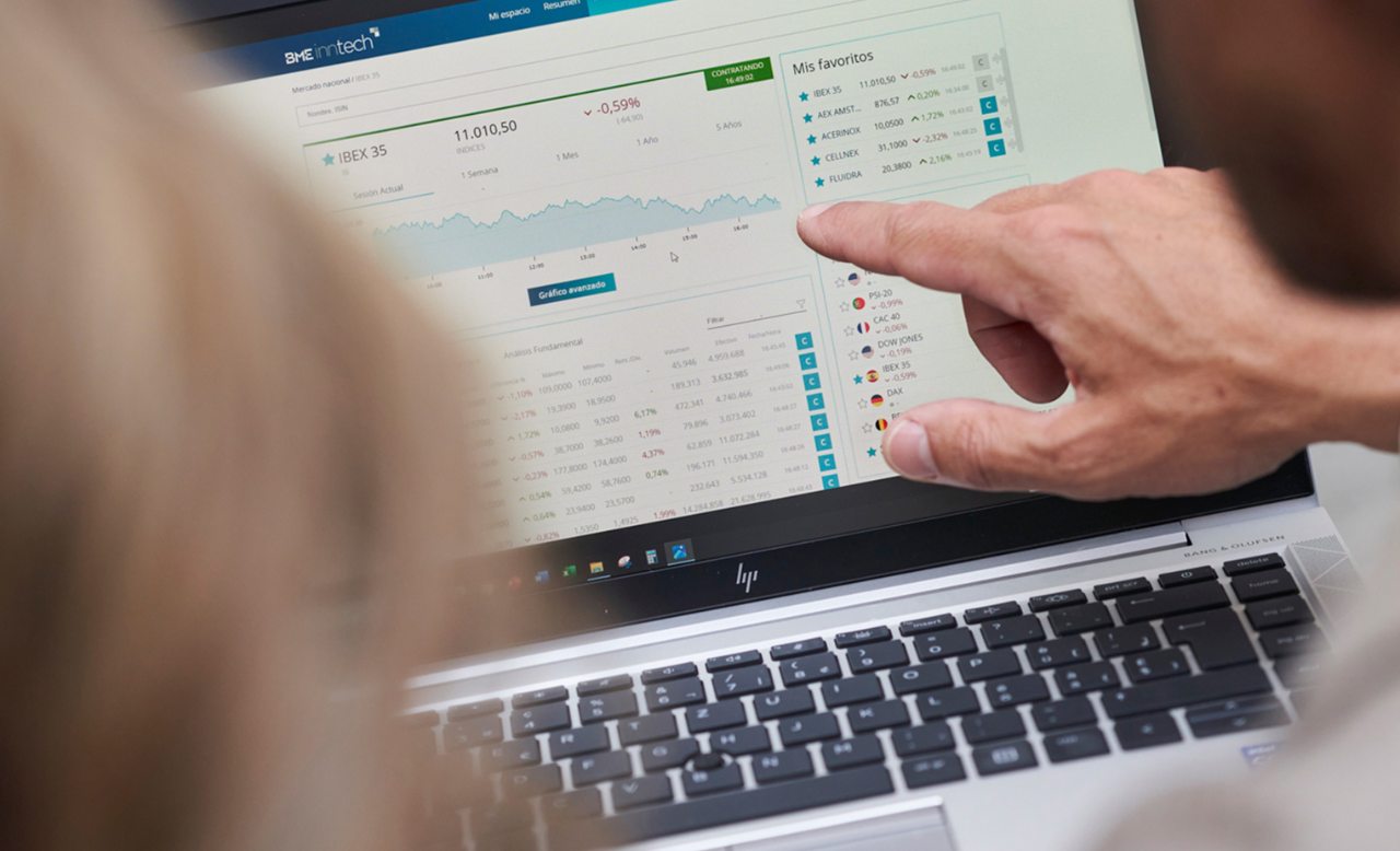 Hombre y mujer frente a un portátil señalando datos