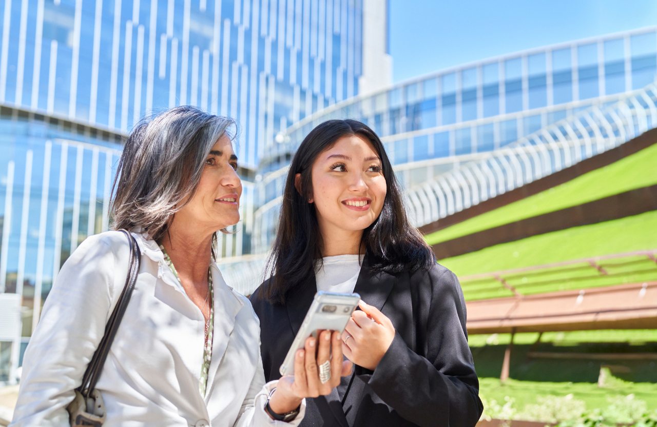 Dos compañeras de trabajo charlando al aire libre 